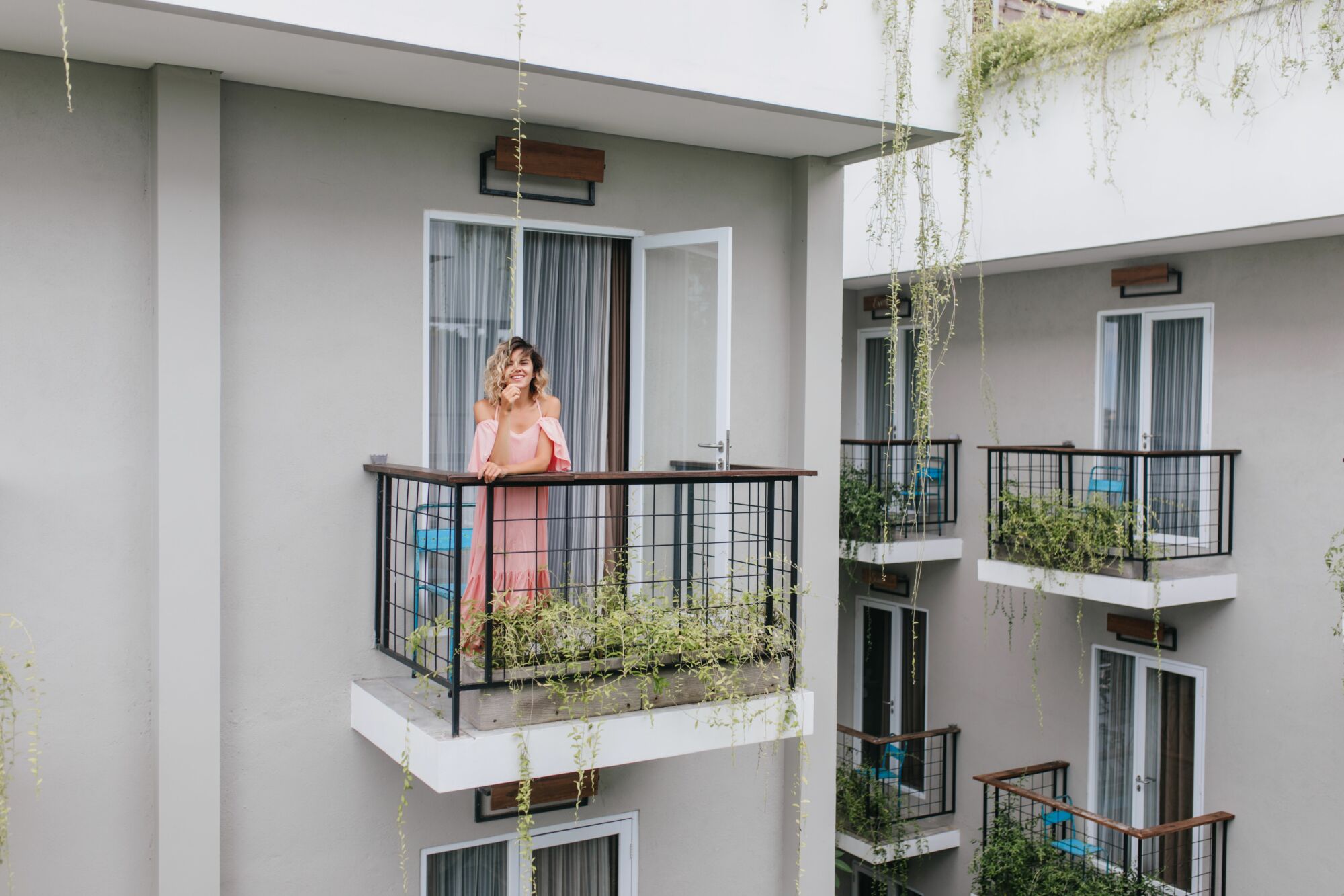 wonderful-caucasian-girl-expressing-happiness-while-posing-hotel-carefree-curly-tanned-woman-pink-dress